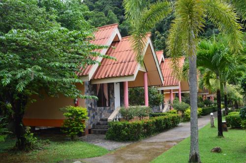 ein Haus mit einem roten Dach und Palmen in der Unterkunft Rim Khao Resort in Ko Lanta