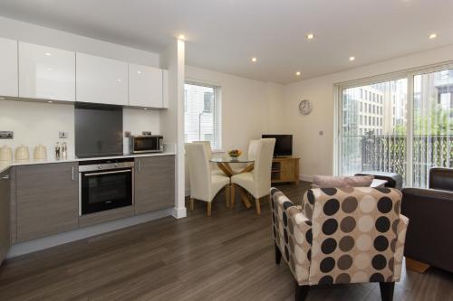 a kitchen and living room with a table and chairs at Citystay Living - Mill Park Apartments in Cambridge