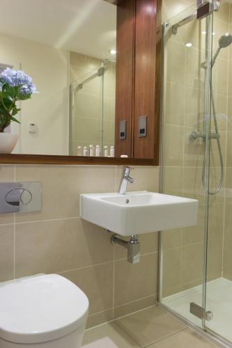 a bathroom with a sink and a toilet and a shower at Citystay Living - Mill Park Apartments in Cambridge