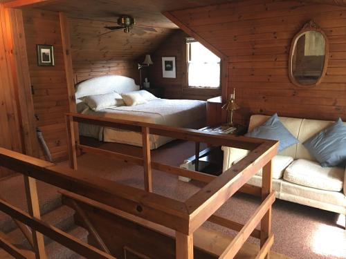 a bedroom with a bed and a couch in a cabin at River House Inn in Grassy Creek