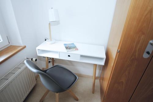 a desk with a chair next to a white desk at Berg Blick Jugendherberge mit Privatzimmer in Kochel