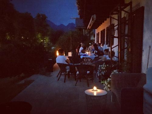 a group of people sitting at a restaurant at night at Berg Blick Jugendherberge mit Privatzimmer in Kochel