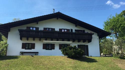 a white house with a balcony on top of it at Berg Blick Jugendherberge mit Privatzimmer in Kochel
