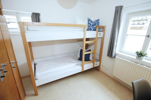 a bunk bed in a room with a ladder at Berg Blick Jugendherberge mit Privatzimmer in Kochel