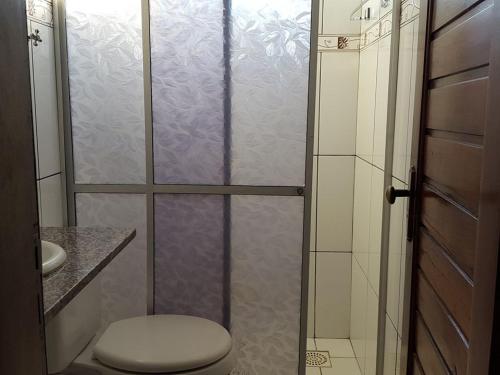 a bathroom with a shower with a toilet and a sink at Hotel Pingo de Ouro in Bacabal
