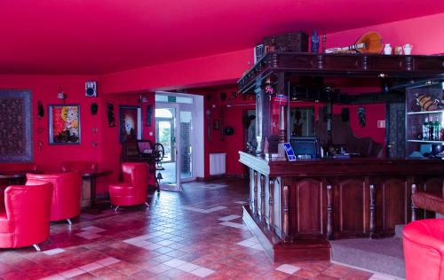 a red room with red chairs and a bar at Hotel Nidzki in Ruciane-Nida