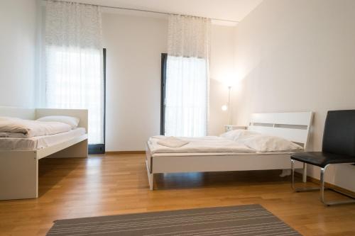 um quarto com duas camas e uma cadeira. em Downtown Apartments em Frankfurt am Main