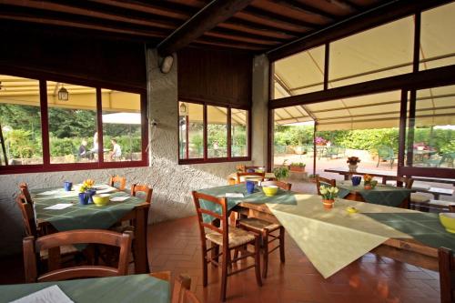 a restaurant with green tables and chairs and windows at Tenuta Il Burchio in Incisa in Valdarno