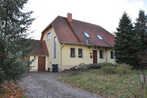 a yellow house with a red roof and a driveway at Ferienhaus Weber in Glashütte