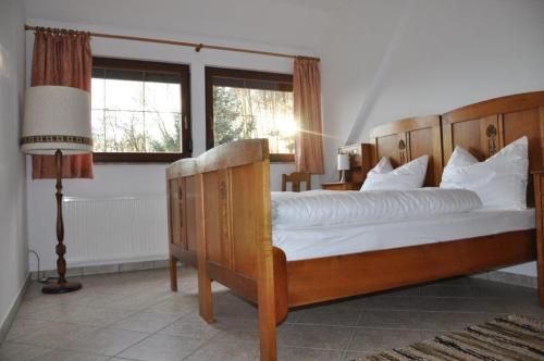 a bedroom with a bed and a lamp and two windows at Ferienhaus Weber in Glashütte