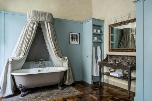 a bathroom with a bath tub and a sink at Hôtel des Saints Pères - Esprit de France in Paris