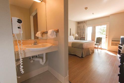 uma casa de banho com um lavatório e um quarto com uma cama em Pine Mountain State Resort Park em Pineville
