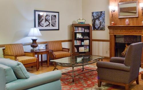 a living room with a table and chairs and a fireplace at Country Inn & Suites by Radisson, Columbus, GA in Columbus