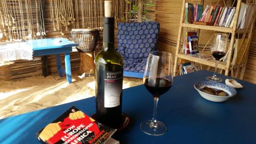 Keta的住宿－A&Y Wild Camp Ghana，一瓶葡萄酒和一张桌子上的一杯