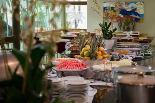 um buffet com pratos e frutas numa mesa em Marulhos Resort by MAI em Porto de Galinhas
