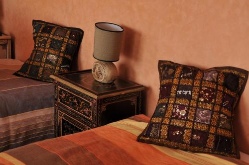 a bedroom with two beds and a lamp on a table at Aftas Trip in Mirleft