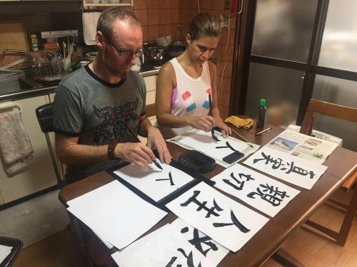 a man and a woman standing at a table signingigraphy at Calligraphy House in Kyoto