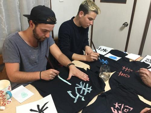 two men are sitting at a table with a table cloth at Calligraphy House in Kyoto