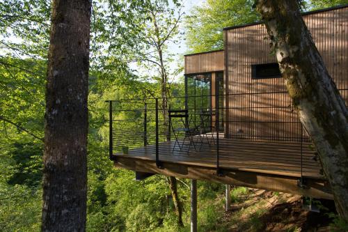 une cabane dans les arbres avec une terrasse dans les bois dans l'établissement Les Cabanes de Salagnac, à Meyrignac-lʼÉglise