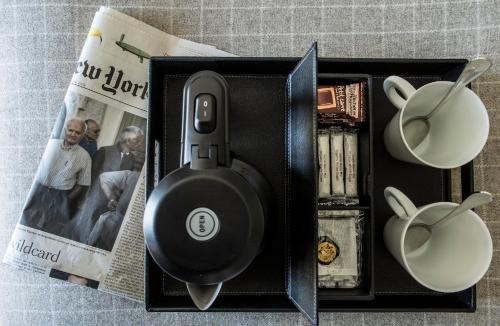 a black speaker in a box next to a magazine at Hôtel d'Orsay - Esprit de France in Paris