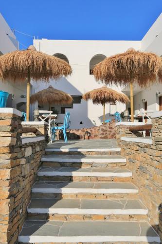 a set of stairs with straw umbrellas and chairs at Sifnos Hotel Benaki in Platis Yialos Sifnos