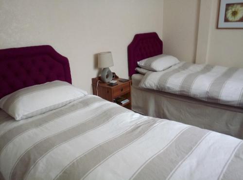 a hotel room with two beds and a table with a lamp at Maggie's in Inveraray