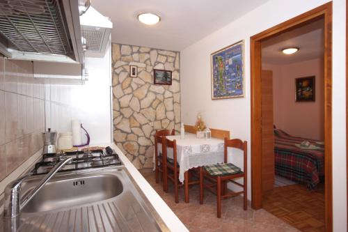 a kitchen with a sink and a table with a stove at Apartment Vesna in Premantura