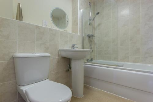 a bathroom with a toilet and a sink and a tub at Citystay - Dove House in Cambridge