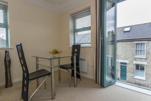 a dining room with a glass table and two chairs at Citystay - Dove House in Cambridge