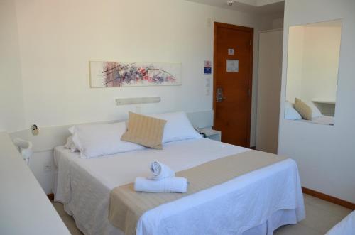 フロリアノポリスにあるLuísa Studio Hotelのタオルが敷かれたベッドのある寝室