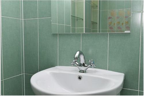 a bathroom with a white sink and a mirror at Apartment on Bulvar Mira 8 in Karagandy