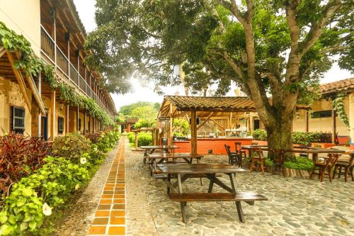 a row of picnic tables and chairs in a courtyard at Decameron Panaca - All Inclusive in Quimbaya