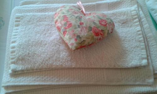 a heart on a towel on a bed at B&B Villa Ca'Praja in Daone