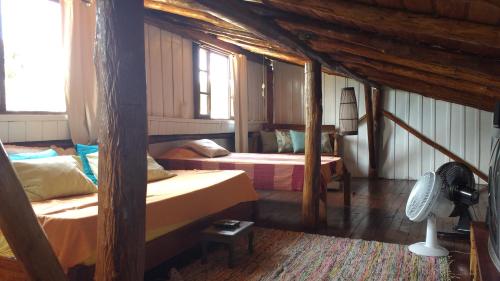 1 dormitorio con 2 camas y ventilador en Casa Mágica, en Praia do Rosa