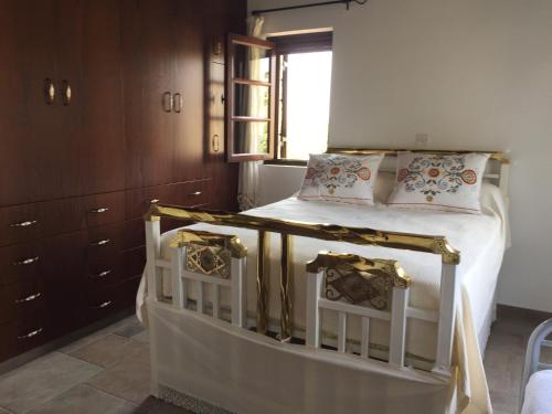 Maroni的住宿－Paradise Traditional House，一间卧室配有一张带白色床单的床和一扇窗户。