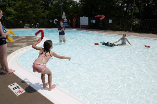 PinevilleにあるPine Mountain State Resort Parkのスイミングプールでフリスビーを遊ぶ集団