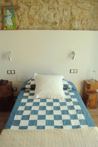 a bed with a blue and white checkeredkered at El Lacayo de Sestiello in Grado