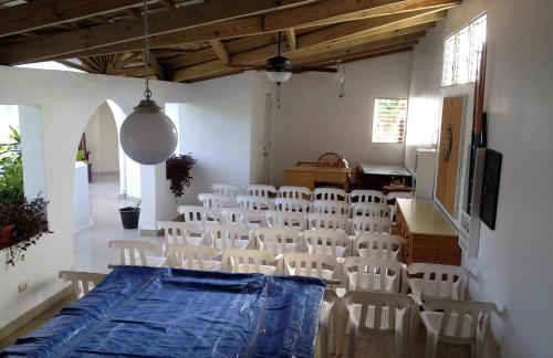a room with white chairs and a table and a table and chairs at Hotel Caribe in Santa Cruz de Barahona