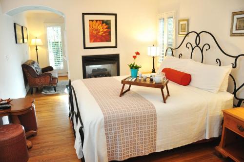 a bedroom with a large bed and a fireplace at The Eagle Inn in Santa Barbara