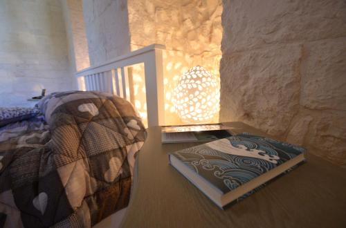 a bedroom with a bed and a book on the floor at Trulli Petra Chiara in Locorotondo
