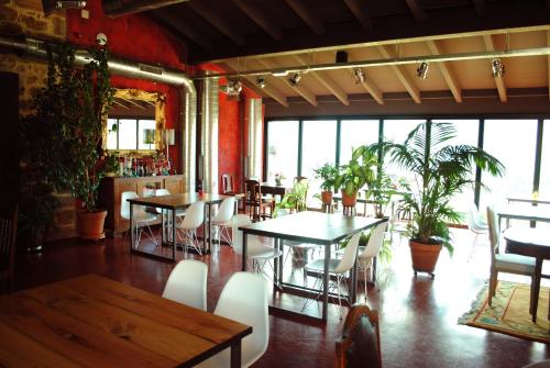 a dining room with tables and chairs and plants at El Lacayo de Sestiello in Grado