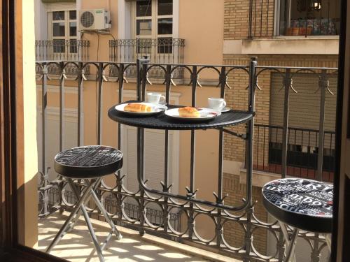 a table with two plates of food on a balcony at Apartamento El Duque in Granada