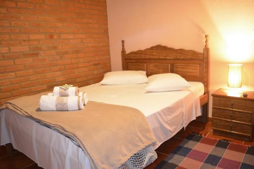 um quarto com duas camas e uma parede de tijolos em Ibitiaçu Chales em Conceição da Ibitipoca