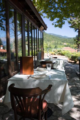 a table with a white table cloth on a patio at Country Club Hotel & Suites in Mikrón Khoríon