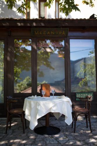 a table with a white tablecloth on it in a restaurant at Country Club Hotel & Suites in Mikrón Khoríon