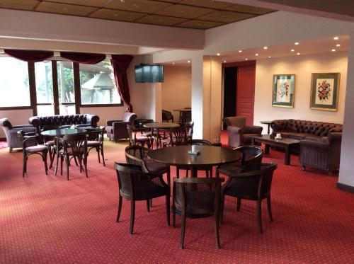a restaurant with tables and chairs in a room at Country Club Hotel & Suites in Mikrón Khoríon