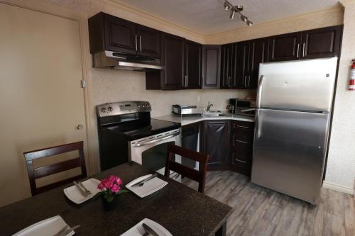 a kitchen with a refrigerator, stove, sink and a microwave at Riviera Hotel on Robson Downtown Vancouver in Vancouver