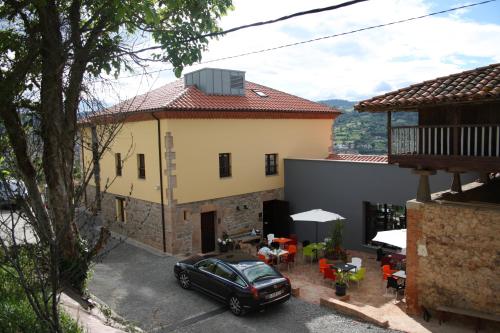 a house with a car parked in front of it at El Lacayo de Sestiello in Grado