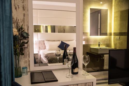a room with a bed and two glasses of wine at Boutique Hotel "Salina" in Ulcinj