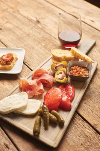 a wooden table with a plate of food and a glass of wine at Hyatt House Boston Waltham in Waltham